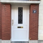 Porte en PVC blanc, avec panneaux à facette et grille imitation fer forgé